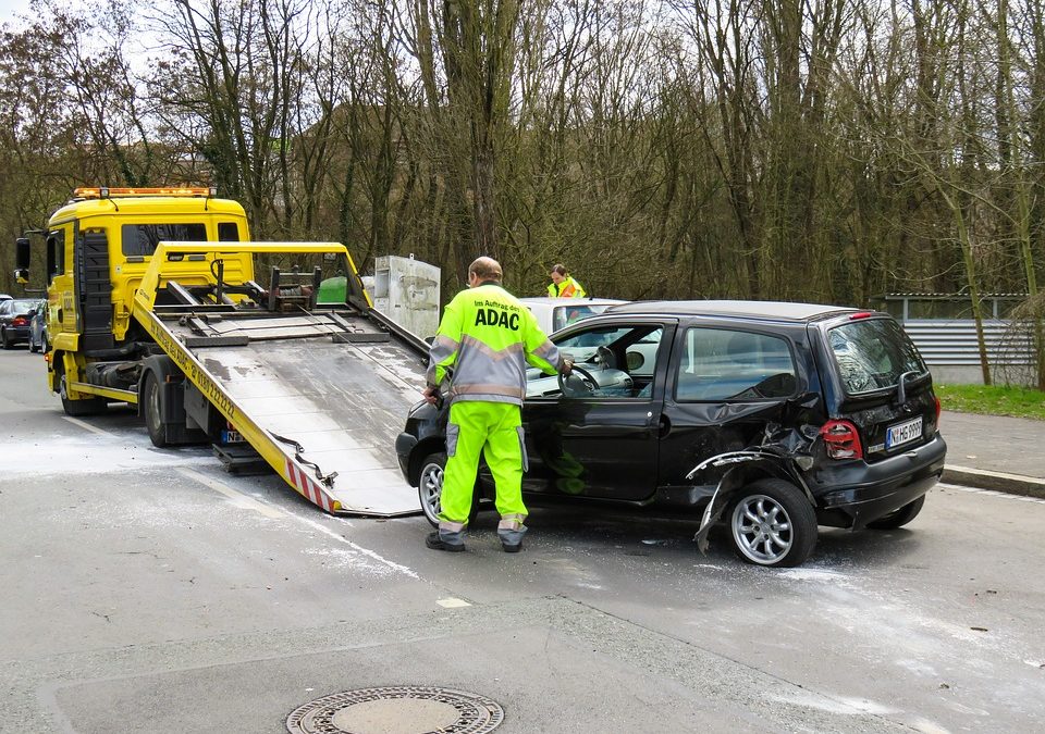 ADAC tow driver loads wrecked car onto back of flattop truck