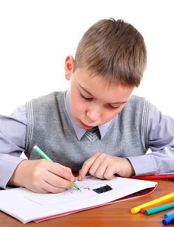 Kid Drawing at the School Desk Isolated on the White Background